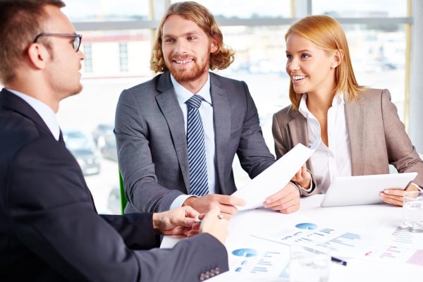 Two business partners listening to interviewee in office