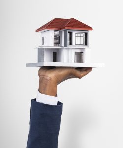 Hand holding house real estate and property model