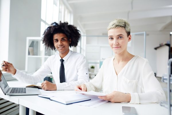 Small group of multi-racial colleagues working over4 project at meeting in office